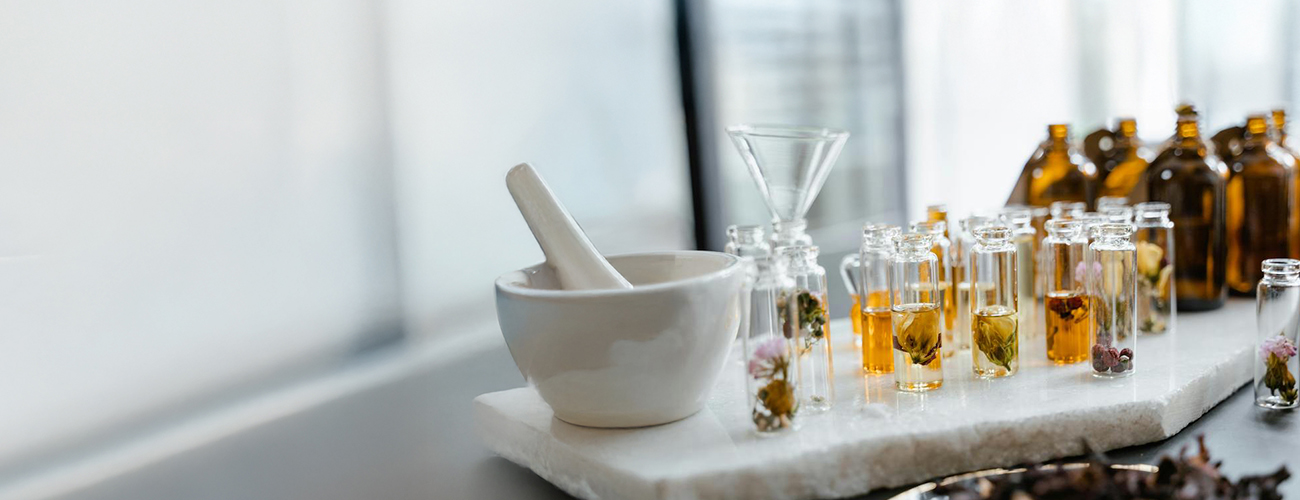 Glass bottles of floral gourmand perfume on white surface