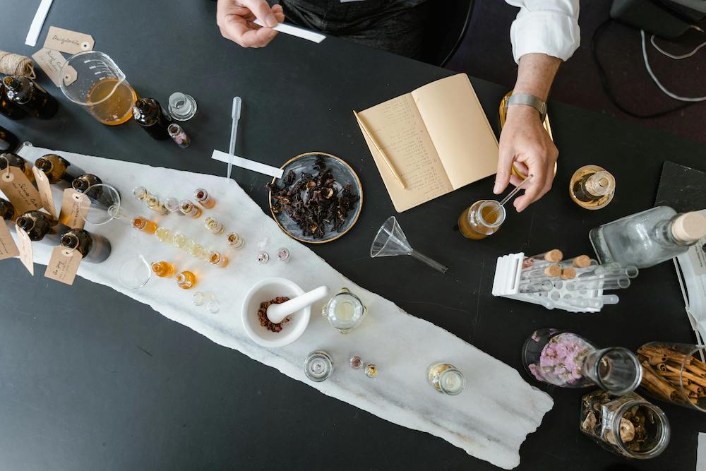Top view of a person mixing liquids to achieve various notes and accords for spring scents
