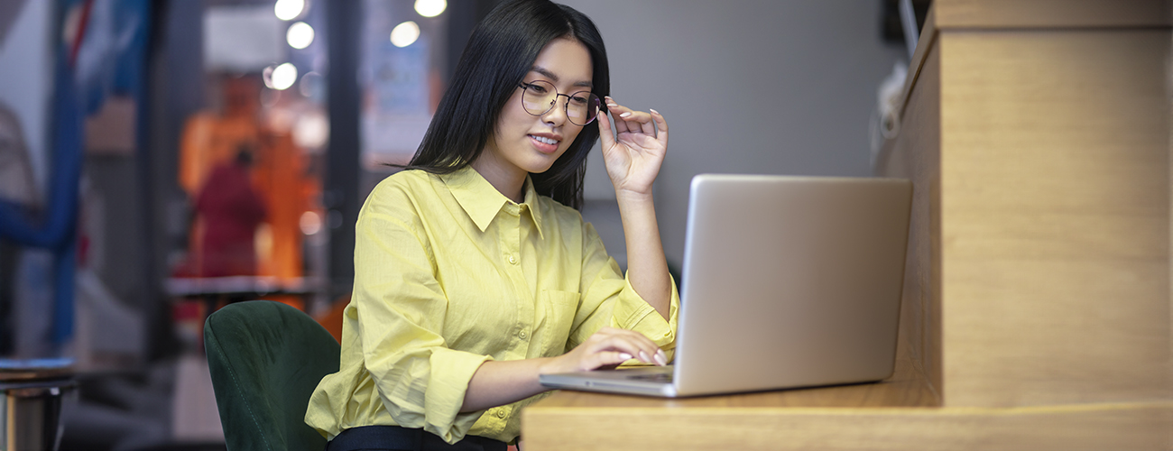 Woman with glasses working on her laptop